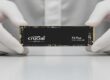 Beyaz eldivenli eller arasında tutulan Crucial P3 Plus NVMe M.2 SSD