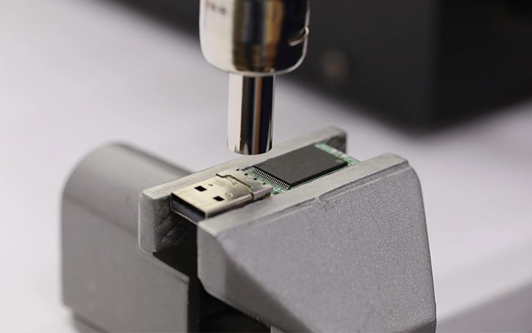 Laboratuvarda mengeneye sabitlenmiş USB bellek kartından sıcak hava ile çip sökme işlemi