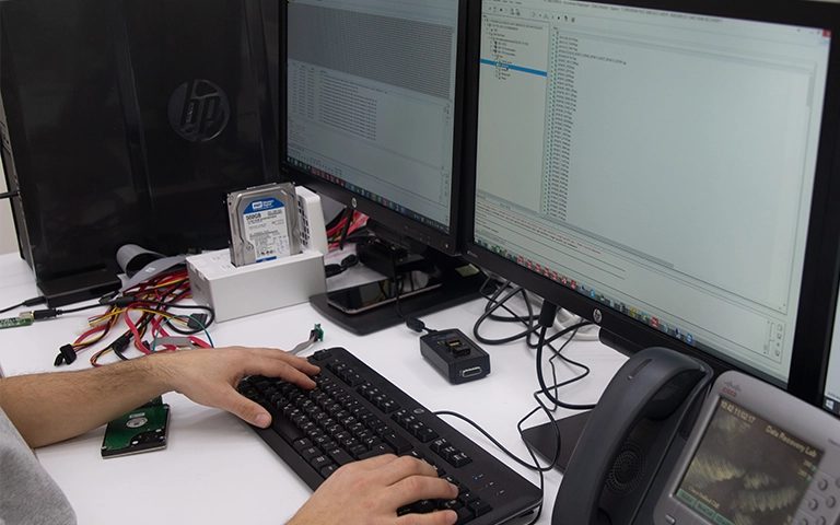 Veri kurtarma mühendisinin iki monitörde disk imajı ve dosya sistemi analizi yapması