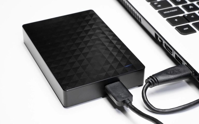 USB kablosuyla dizüstü bilgisayara bağlı siyah desenli Seagate harici disk