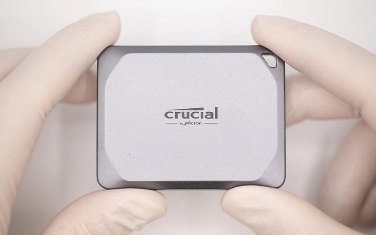 Eldivenli ellerde tutulan Crucial X9 Pro taşınabilir SSD